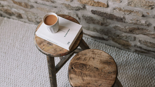 Two reclaimed wooden stools with tea and book on top.