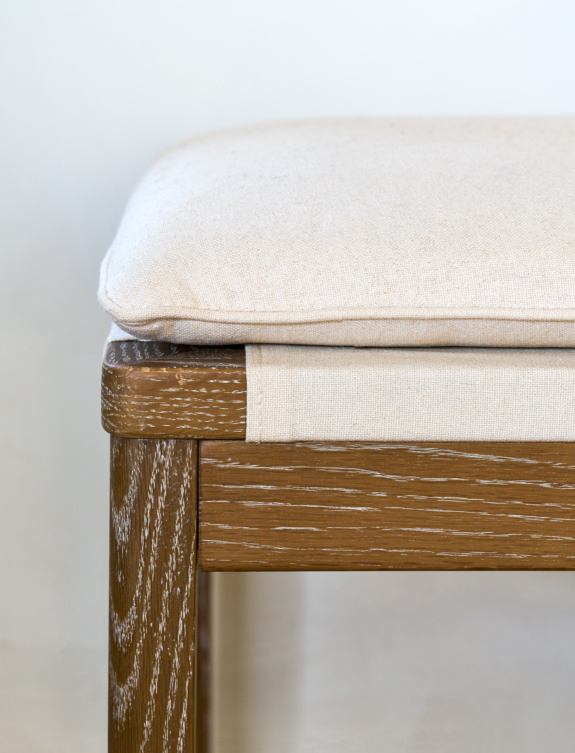 Wooden bench seating with cushions on a plain background