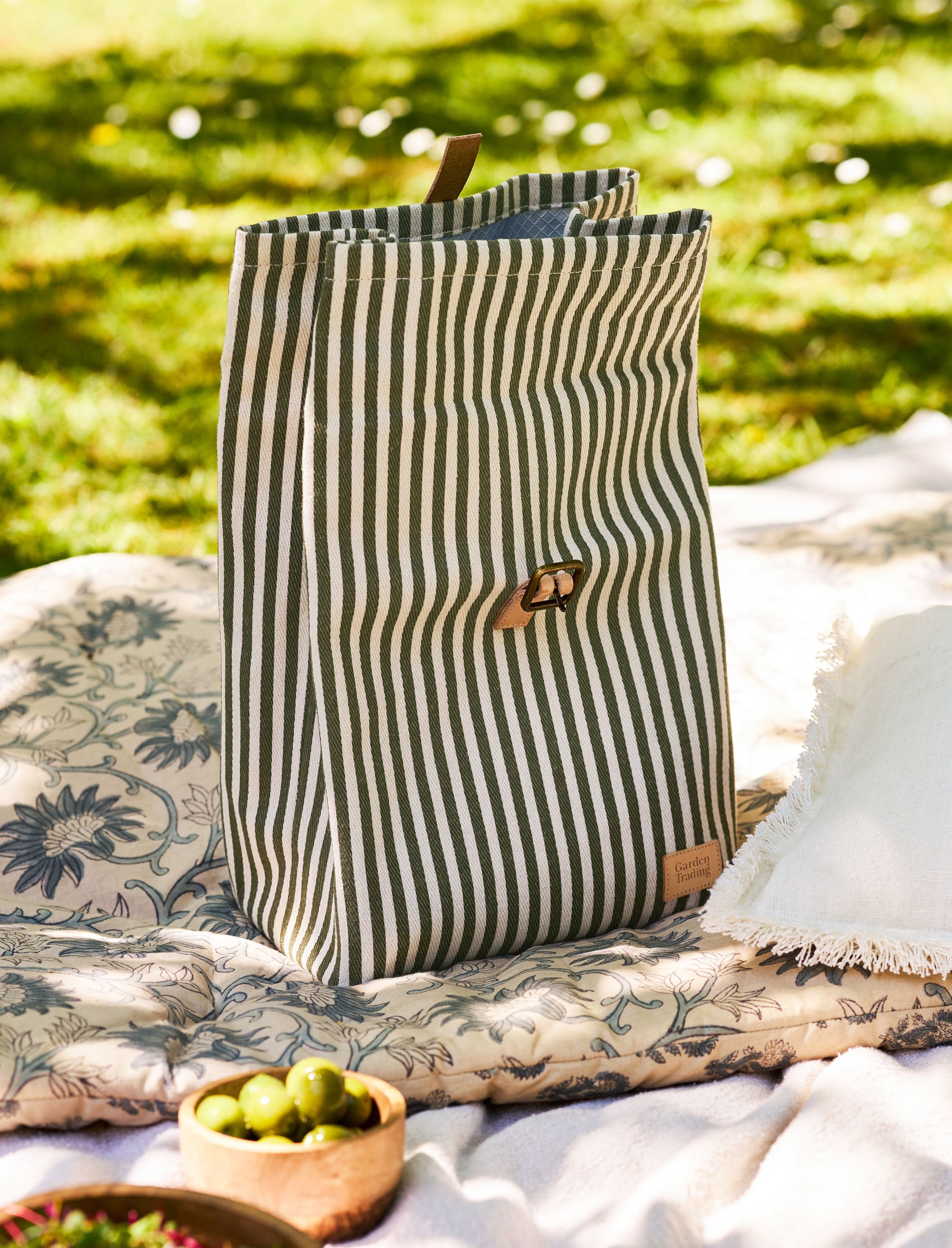 Striped lunch bag on a blanket with greenery in the background
