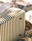 Striped fabric picnic bag with a ribbon on a floral-patterned surface