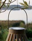 Close up of solar panel on antique zinc solar LED lantern, hanging on a tree.