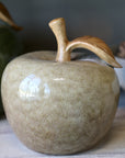 Ceramic apple decor with a leaf on a wooden surface