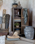Tall reclaimed wooden with the door open, filled with textiles, blankets and plants.