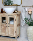 Natural wood rustic cabinet with sink on top in bathroom.