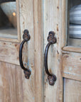 Close up of iron handles on natural wood rustic cabinet.
