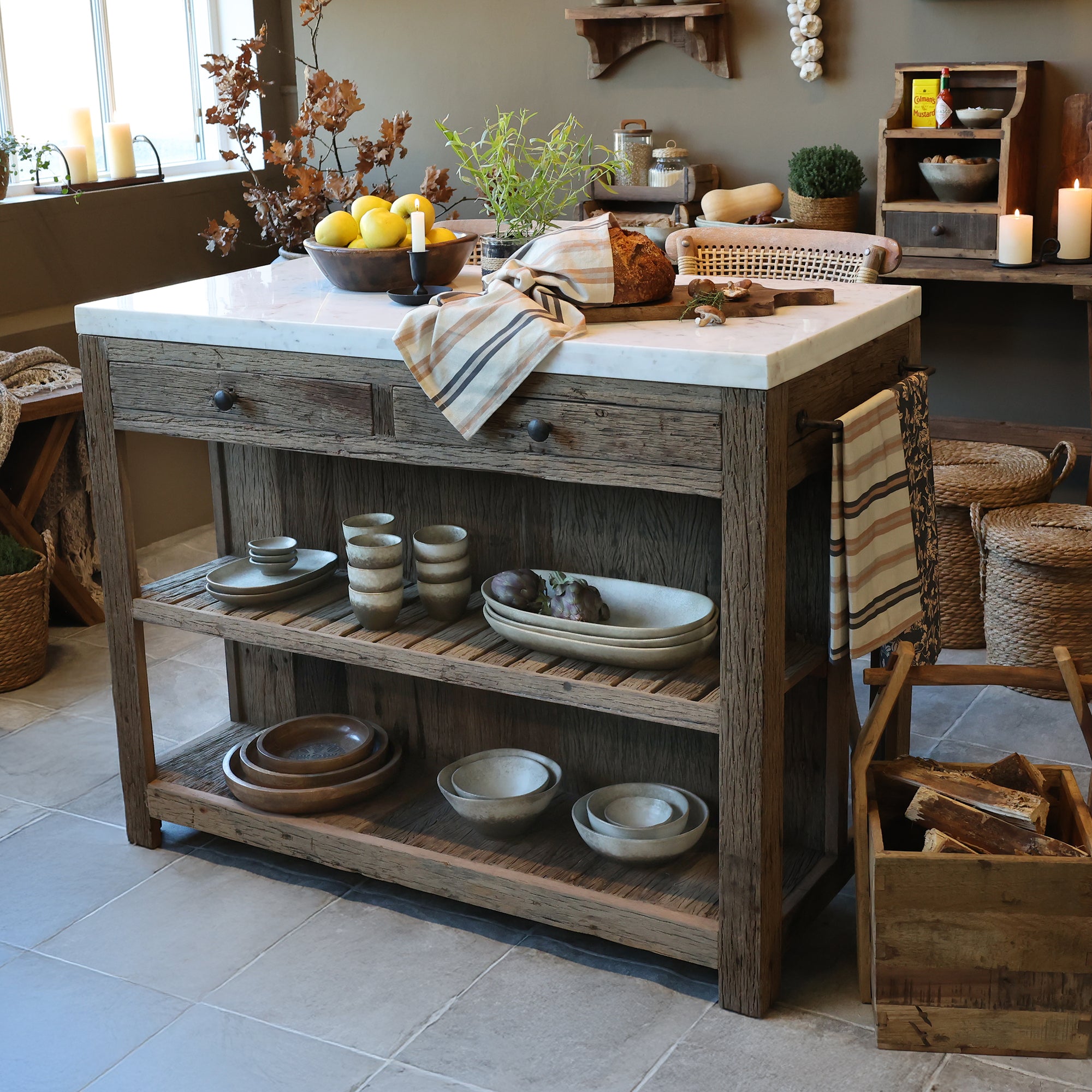 Wooden butchers block with a marble top, with ceramic dishes in a rustic kitchen setting