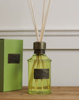 Home fragrance dark rum and lime green reed diffuser on wooden console with presentation box