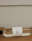 Sences Alang Alang White Diffuser Refill on it's side on a wooden console