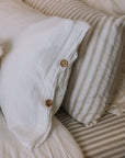 White and striped bedding with wooden button detailing.