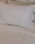 White and striped bedding with buttons.