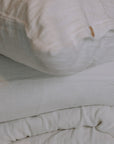 White muslin bedding with wooden button details.