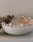 Cream ceramic bobble bowl with purple foliage.