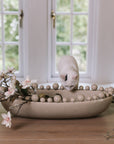 Cream oval bobble bowl with magnolia flowers and a white kitten.