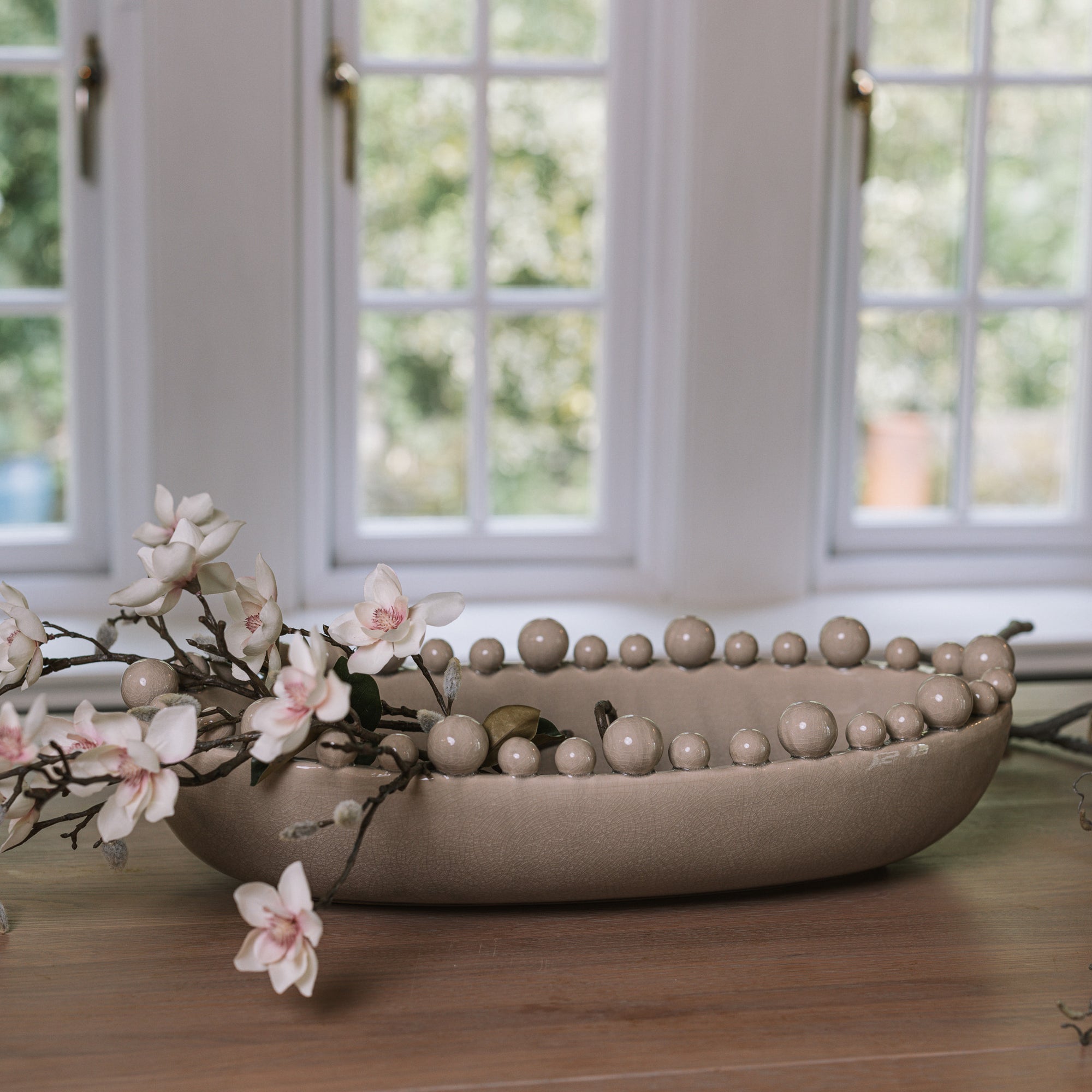 Cream oval bobble bowl with magnolia flowers.