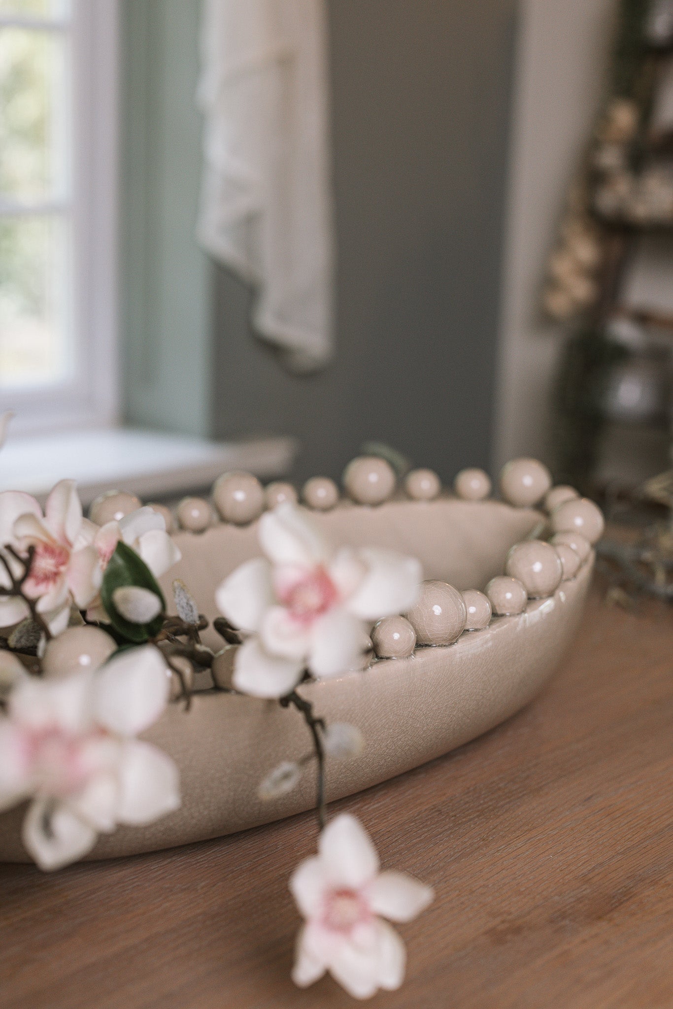Cream oval bobble bowl with magnolia flowers.