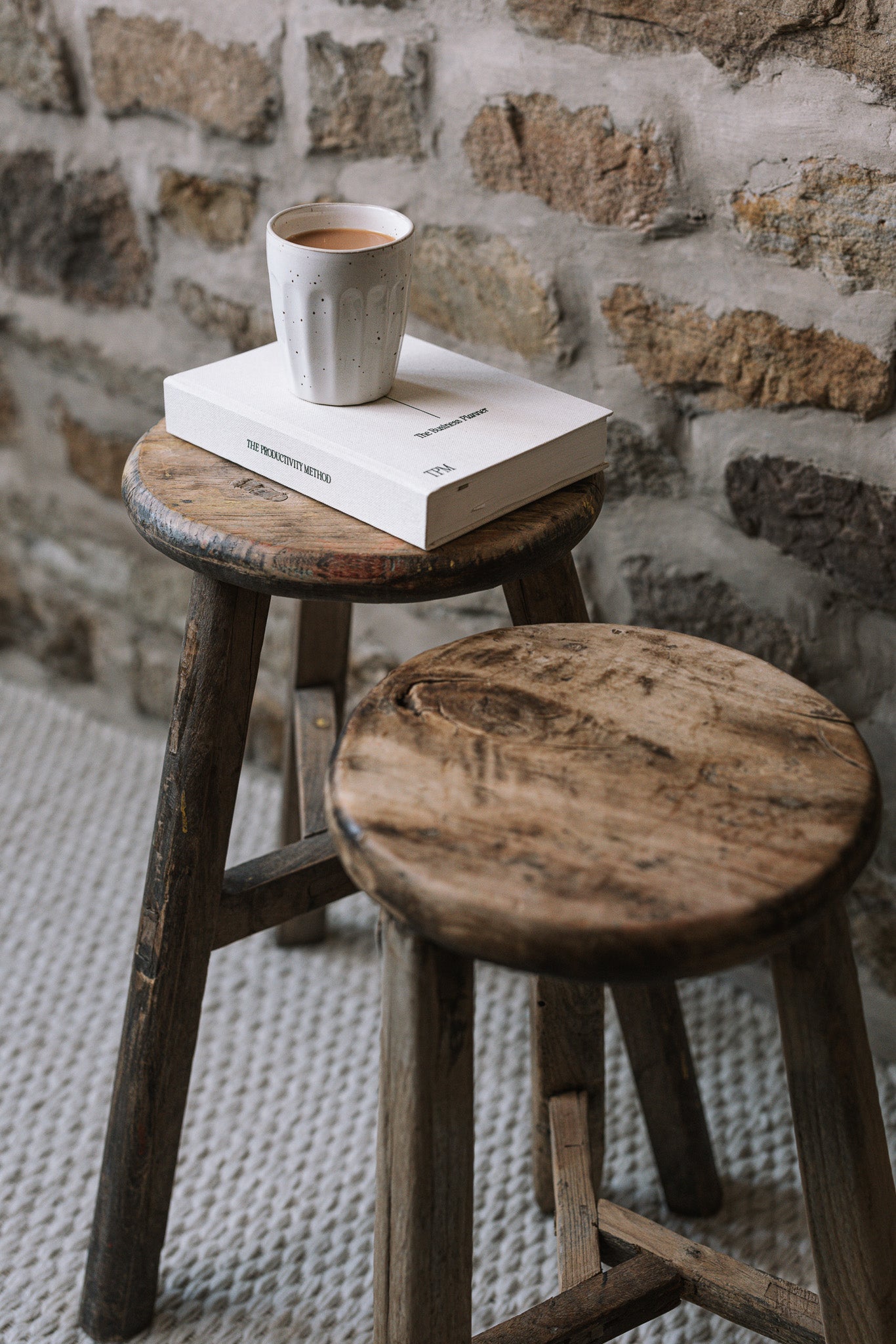 Pair of reclaimed wooden stools with book and cup of tea.