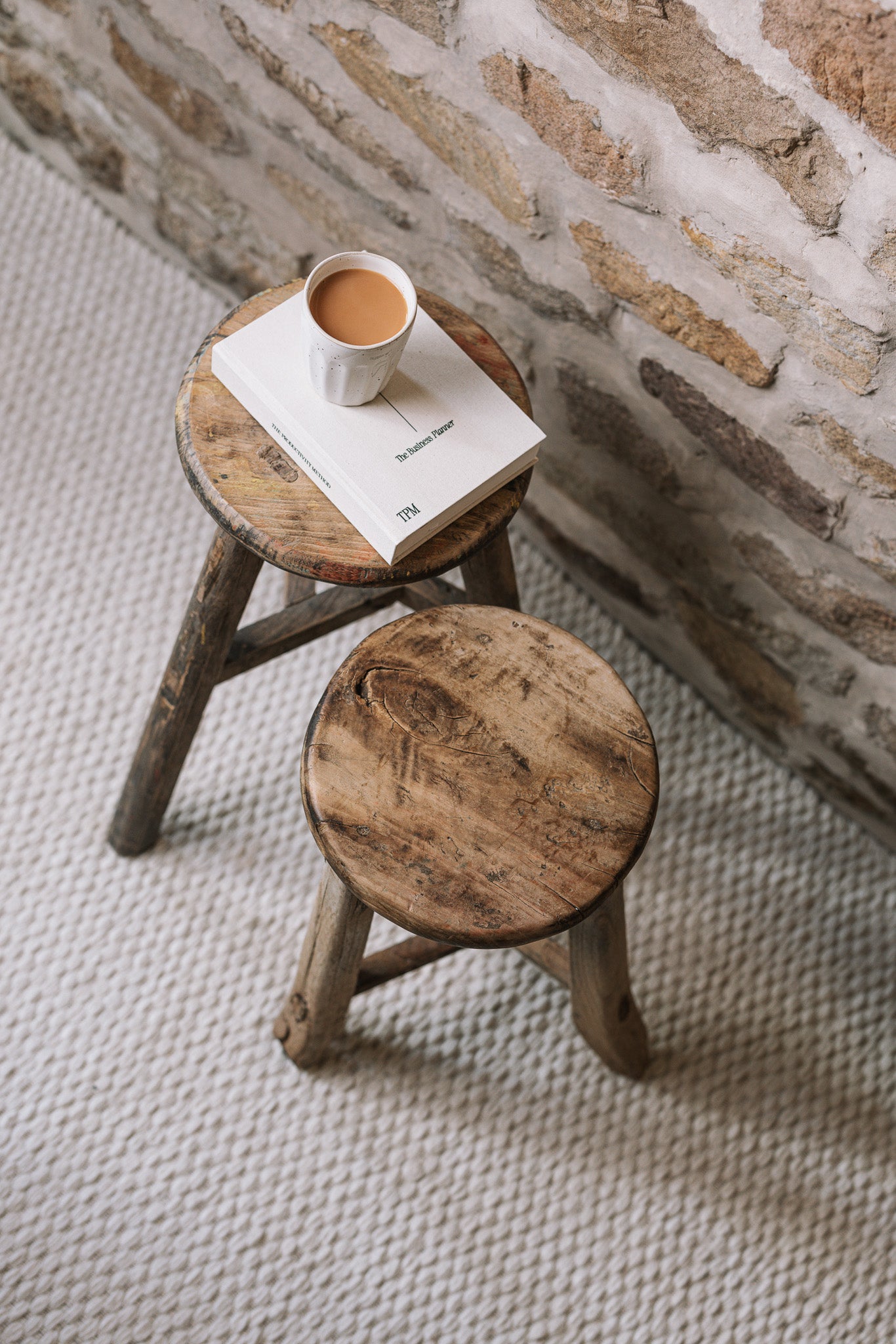 Pair of reclaimed wooden stools with book and cup of tea.