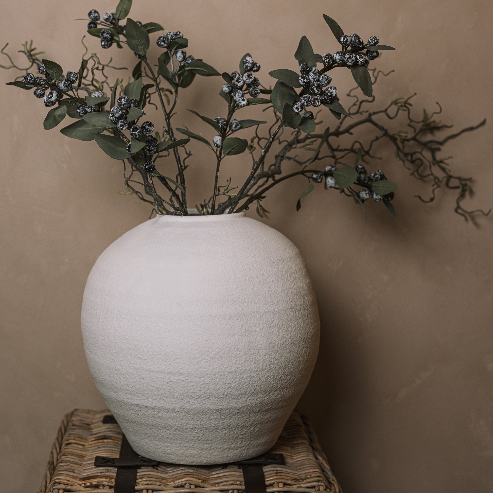 Ceramic round white textured vase with berry sprays and branches.