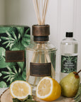 Home fragrance citrus verbena reed diffuser with lemons and greenery.