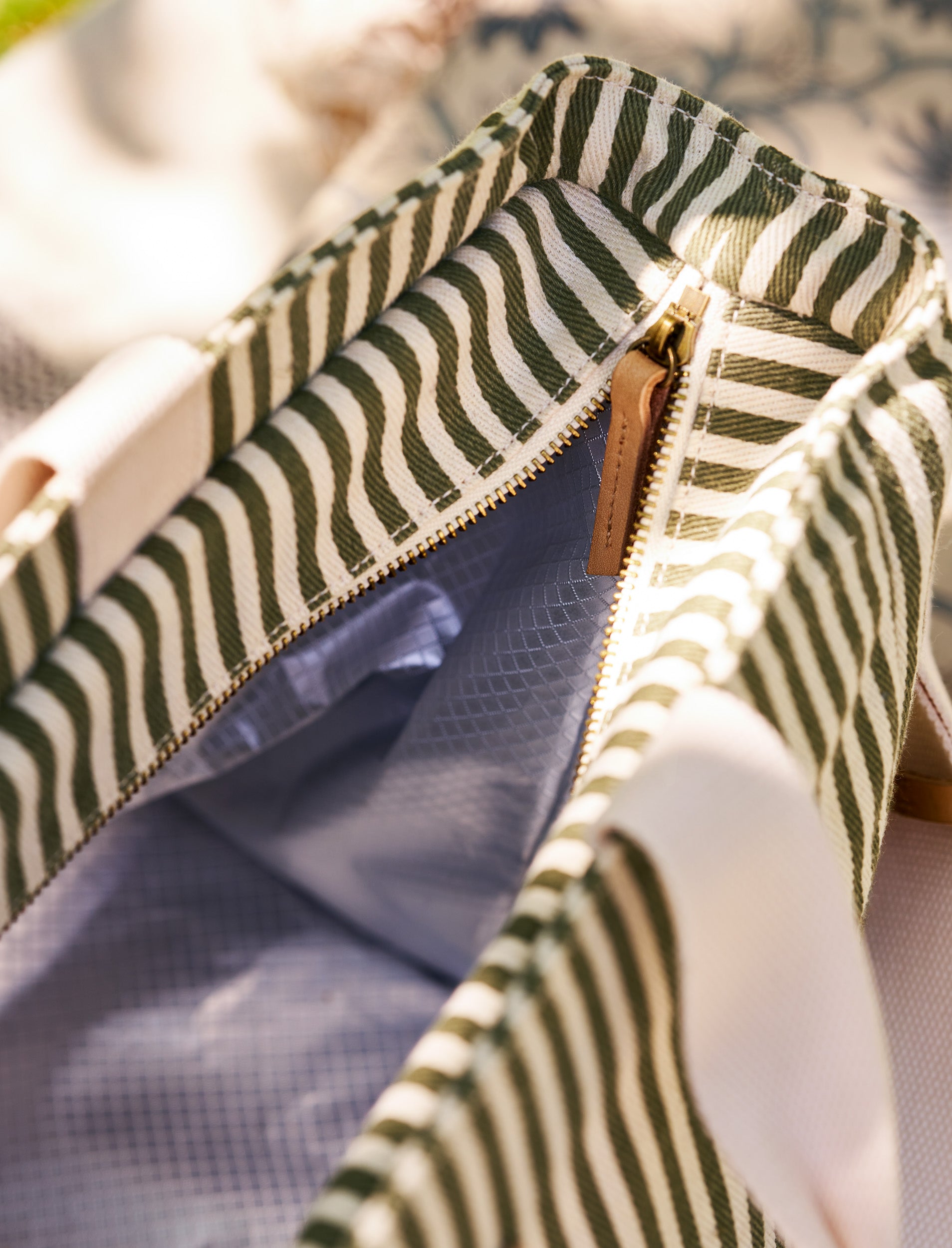 Close-up of a striped cotton picnic bag with a zipper, possibly from a garment.
