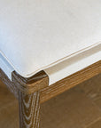 Close-up of a wooden bench seating with cushions and backrest.