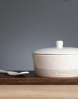 Stoneware Cheese Baker Set on wooden paddle.