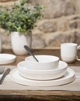 a dinner place with plate, pasta bowl and small bowl.