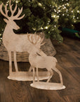 2 white reindeer decorations with tree.