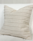 Cream embroidered cushion on a white sofa.