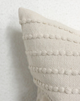 Close up of detailing on cream embroidered cushion.