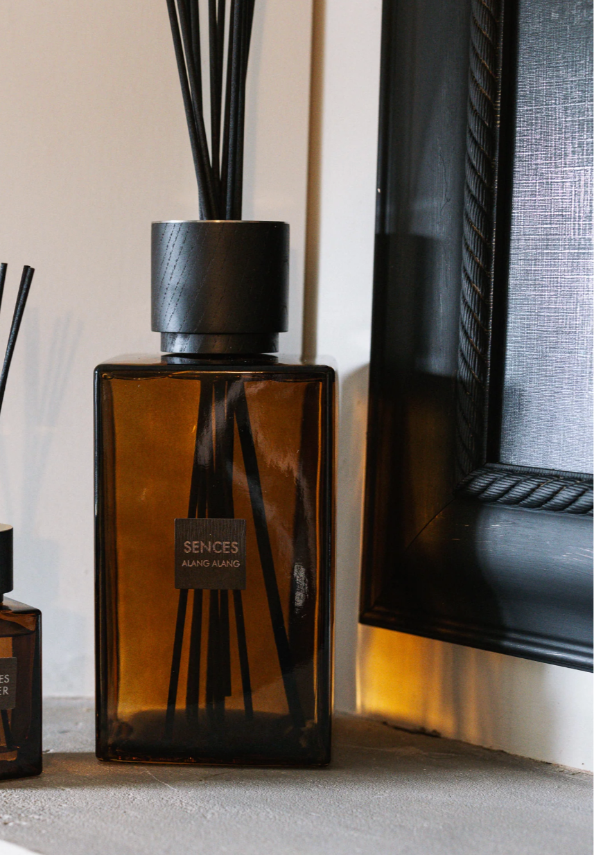 Amber large reed diffuser with mini version on stone mantle piece.