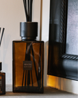 Amber large reed diffuser with mini version on stone mantle piece.