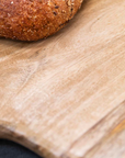 Close up of round wooden serving board with bread on.