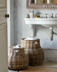 Bathroom with rattan storage baskets, marble tiles, and a sink.