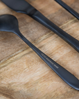 Close up of stainless steel marking on black cutlery set.