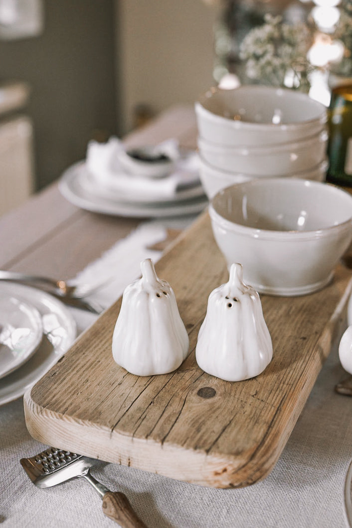 butternut squash salt and pepper shakers on a neutral table with wooden serving board.