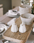 butternut squash salt and pepper shakers on a neutral table with wooden serving board.