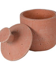 Small terracotta decorative jar with lid off.