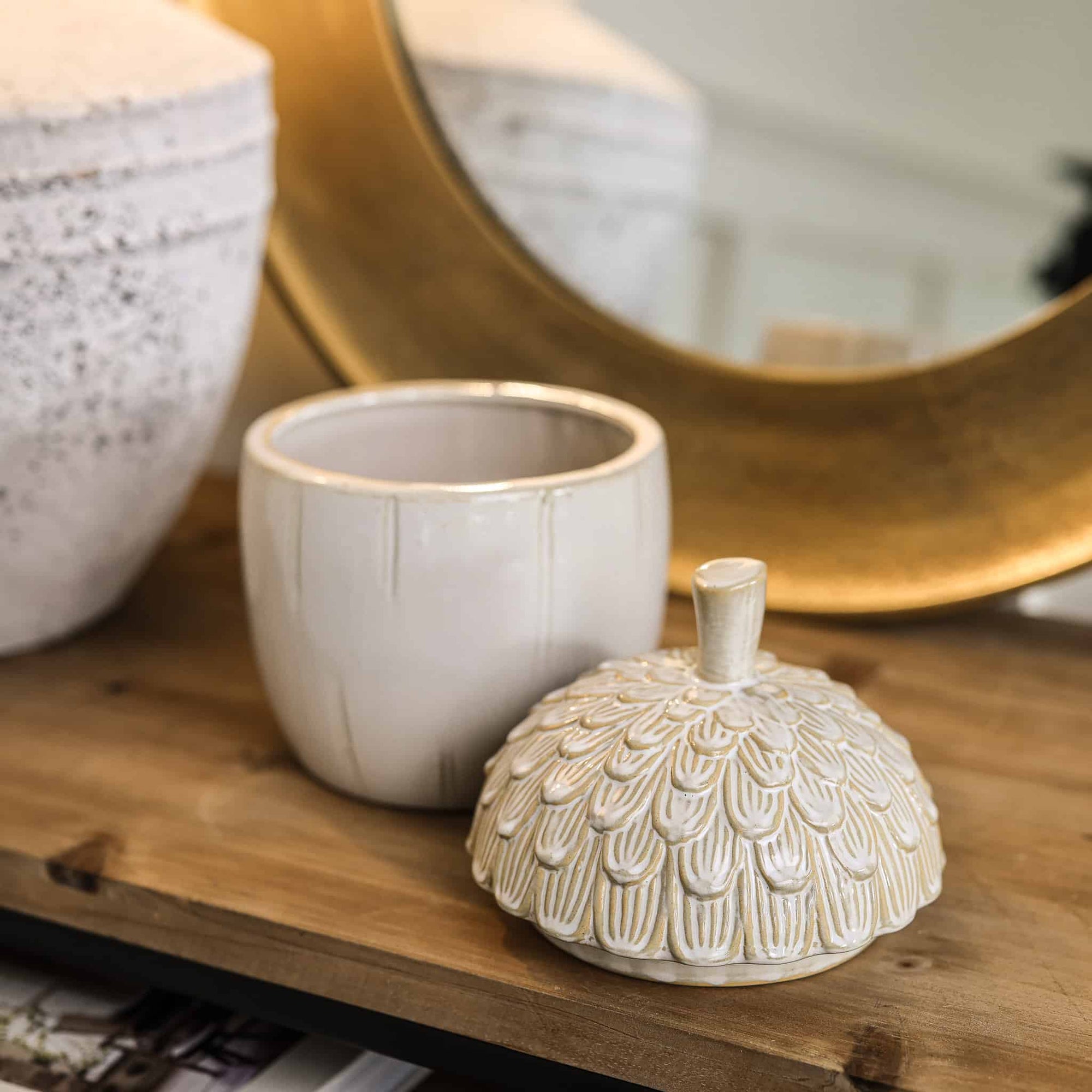 Ceramic acorn storage jar with lid off.
