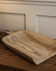 Wooden tray with rope on wooden console.