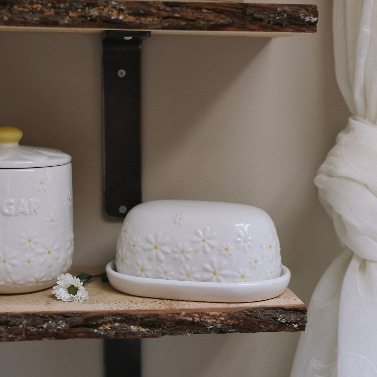 Daisy Embossed Butter Dish on wooden shelf