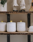 Daisy Tea coffee sugar canisters on wooden shelf with butter dish