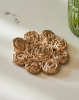 Woven jute coaster with rose design on a white surface