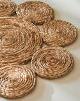 Set of woven round jute placemats on a light surface