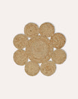 Round woven jute placemat with concentric circles on a light gray background