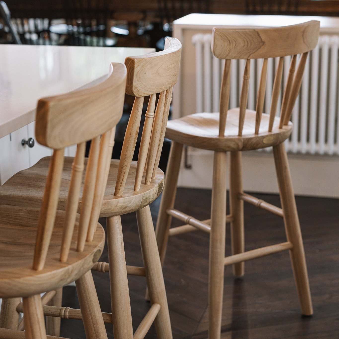 Three Farmhouse Bar Stools With Backs in dark wood kitchen.