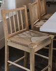 Farmhouse Rattan Bar Stool in kitchen with dark wood floor.