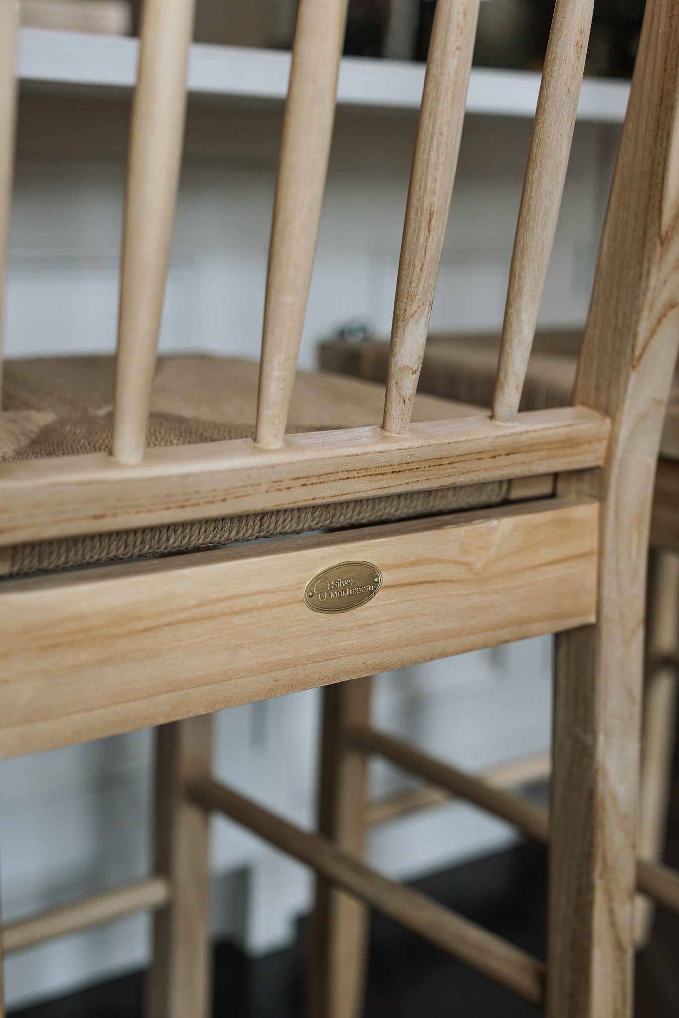 Farmhouse Rattan Bar Stool in kitchen with dark wood floor with badge.