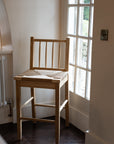 Farmhouse Rattan Bar Stool in kitchen with dark wood floor by the window.