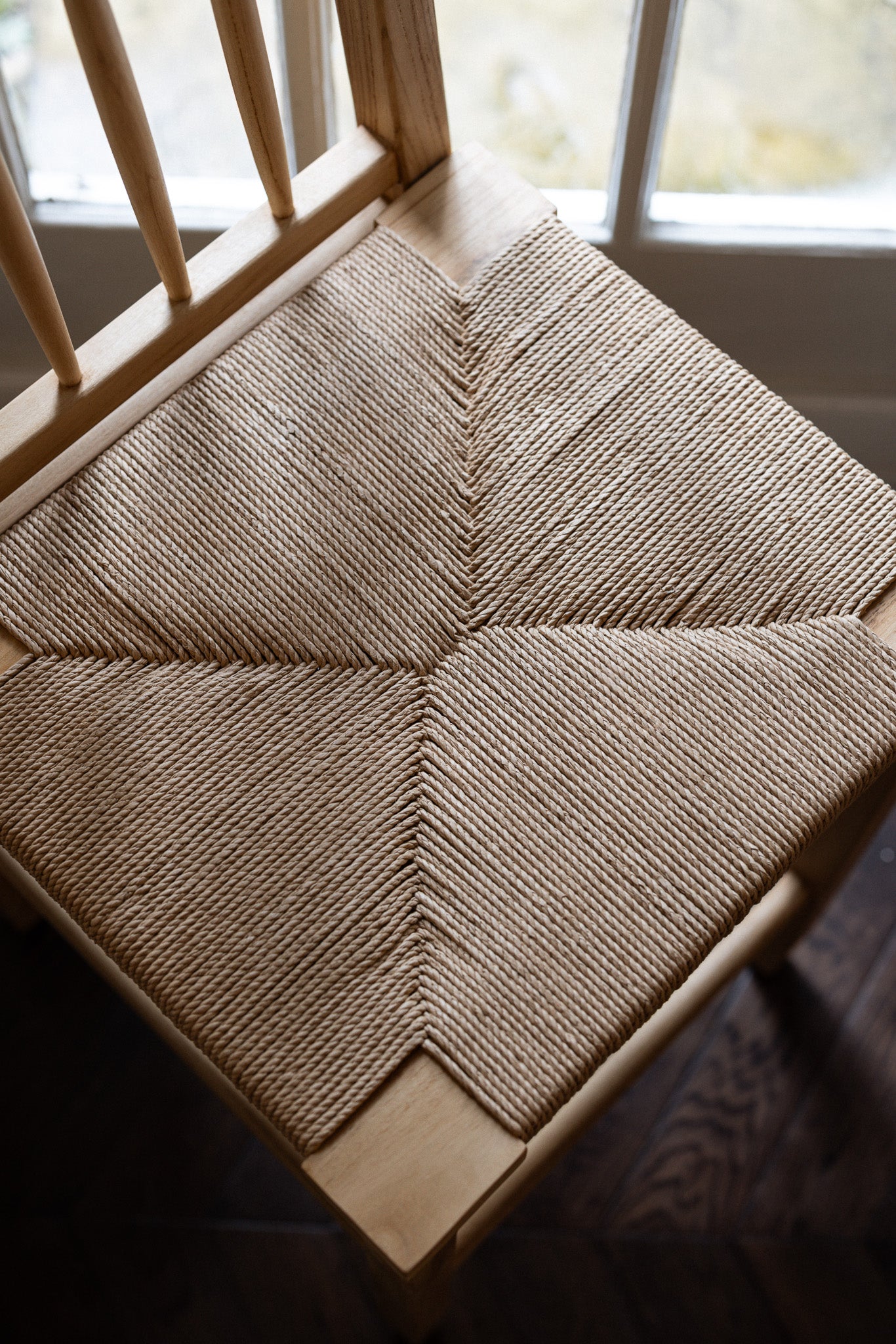 Farmhouse Rattan Bar Stool in kitchen with dark wood floor from birds eye view.